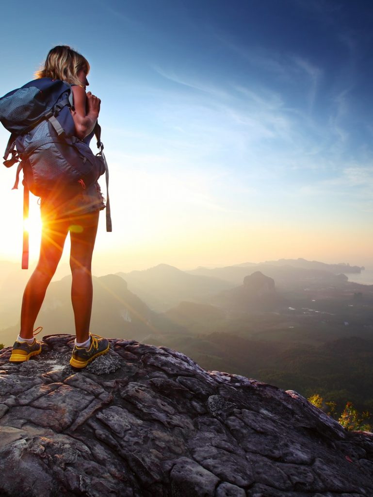 Image of Traveler standing on top of mountain for her SEO for travel blogs.